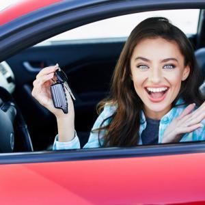 A woman in a red car after getting a car insurance policy from Compare Insurance Ireland.