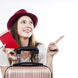 A woman holding a red passport and a travel insurance policy