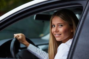 Girl driving a white car.