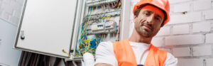 electrician standing beside an electric box
