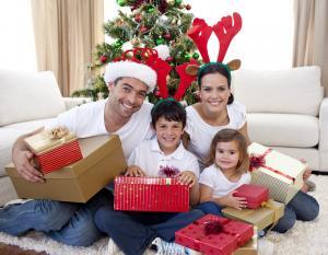 A family celebrating Christmas at home in Ireland with wrapped gifts under the tree