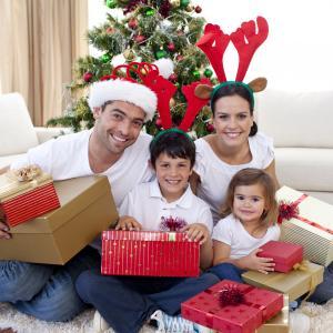 A family celebrating Christmas at home in Ireland with wrapped gifts under the tree